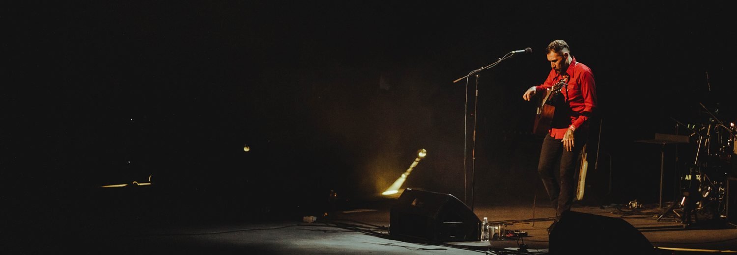 Kill Aniston en concierto, con guitarra acústica